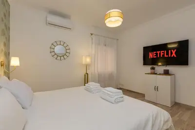 a bedroom with a white bed and a tv on the wall at Cozy Apartment Monteverde near Trastevere in Rome