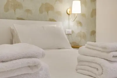 a bedroom with white towels stacked on a bed at Cozy Apartment Monteverde near Trastevere in Rome