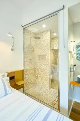 a glass shower in a bedroom with a bed at Casa Cipradino in Rome