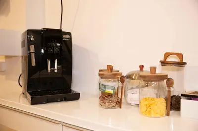 a coffee maker on a counter next to jars of food at Casa Cipradino in Rome