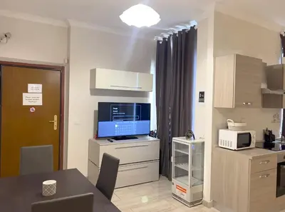 a room with a kitchen with a tv and a table at Ariana Apartments in Rome