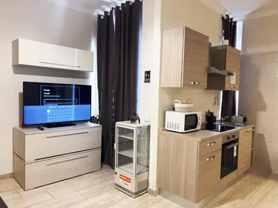 a kitchen with wooden cabinets and a microwave at Ariana Apartments in Rome