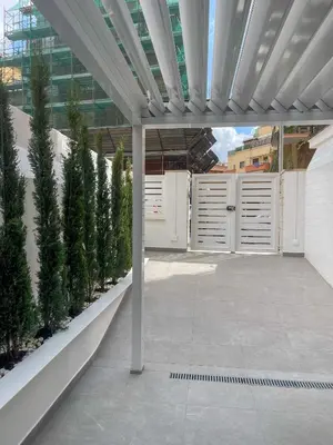 a patio with white doors and some trees at Alissa Suite in Rome