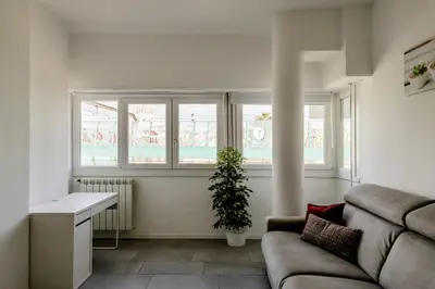a living room with a couch and two windows at Vatican View in Rome