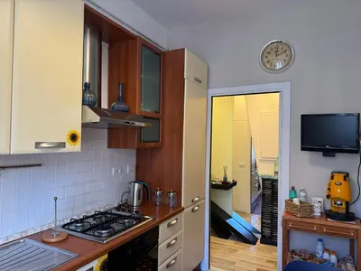 a kitchen with a stove and a clock on the wall at Dora Apartment in Rome