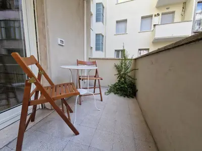 a patio with a table and chairs on a balcony at Incantevole appartamento nel Parco dell'Aniene! in Rome