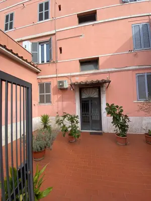 a pink building with potted plants in front of it at Residenza AURELIA in Rome