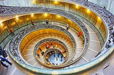 a spiral staircase in a building with people walking down it at Residenza AURELIA in Rome