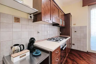 a kitchen with wooden cabinets and a stove top oven at Centro Storico a 15' - Cata Apartment Roma in Rome