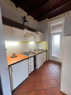 a kitchen with white cabinets and a tile floor at Trastevere al Leopardo in Rome