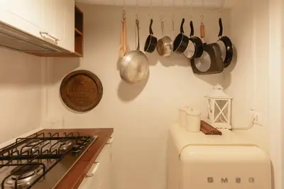 a kitchen with a refrigerator and pots and pans on the wall at Piazza Navona Historic Luxury Apartment in Rome