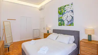 a bedroom with a bed and a painting on the wall at Domus San Giovanni Elegant Apartment in Rome