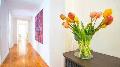 a vase of flowers on a table in a hallway at Domus San Giovanni Elegant Apartment in Rome