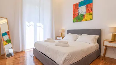 a bedroom with a large bed with white sheets at Domus San Giovanni Elegant Apartment in Rome