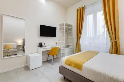 a bedroom with a bed and a desk and a tv at SCIPIONI 40 GUESTHOUSE in Rome