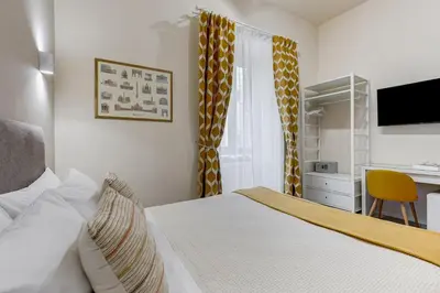 a bedroom with a bed and a desk with a computer at SCIPIONI 40 GUESTHOUSE in Rome