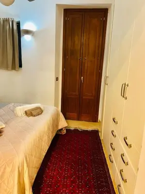 a bedroom with a bed and a red rug in front of a door at Trastevere Moro apartment in Rome