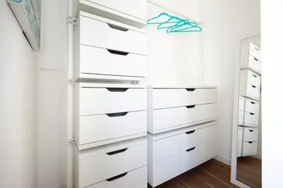 a closet with white drawers and a mirror at Apartment near the Vatican Cipro metro station in Rome