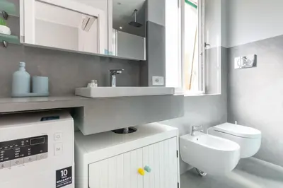 a white bathroom with a sink and a toilet at Apartment near the Vatican Cipro metro station in Rome