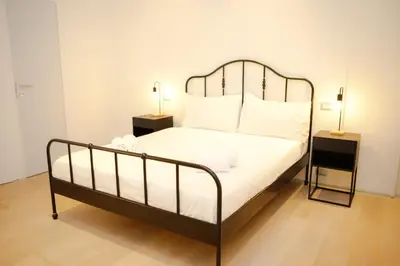 a bedroom with a white bed with a metal headboard at Magikrooms Kandy in Rome