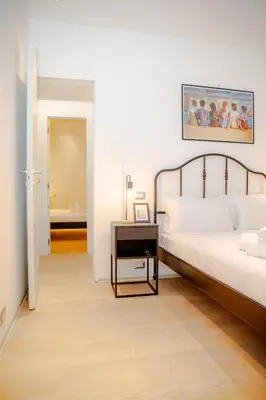 a bedroom with a bed and a night stand next to a table at Magikrooms Kandy in Rome