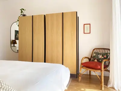 a bedroom with a large wooden partition with a chair at Be Close - Porta Portese Appartamento con terrazza in Rome