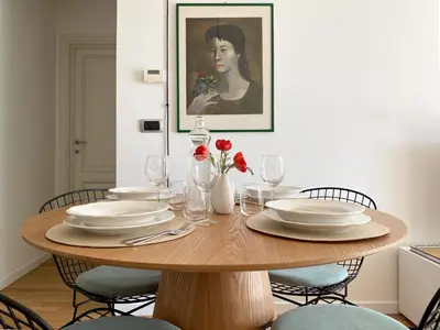 a dining room table with plates and flowers on it at Be Close - Porta Portese Appartamento con terrazza in Rome