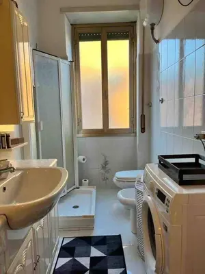 a bathroom with a sink and a washing machine at Di Donato Apartment in Rome