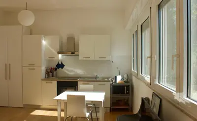 a kitchen with white cabinets and a table and chairs at Quadrilatero Flat in Rome