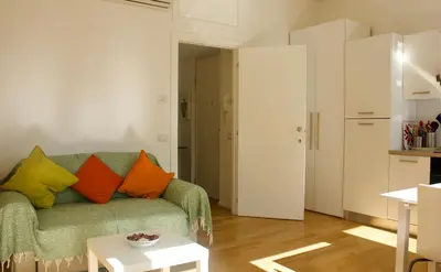 a living room with a green couch with colorful pillows at Quadrilatero Flat in Rome