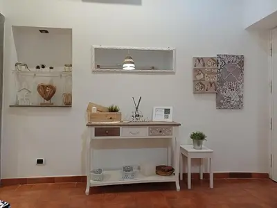 a room with a white wall with a table and a mirror at Il barone di Trastevere in Rome