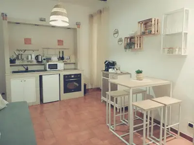 a kitchen with a table and two stools at Il barone di Trastevere in Rome