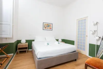a bedroom with a white bed and a green wall at Piazza Cavour Zen Garden-ZEN36 in Rome