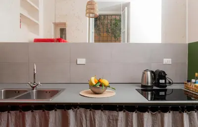 a kitchen with a bowl of fruit on a counter at Piazza Cavour Zen Garden-ZEN36 in Rome