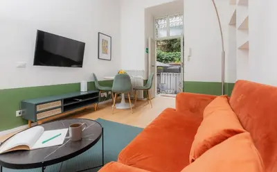 a living room with a couch and a table at Piazza Cavour Zen Garden-ZEN36 in Rome