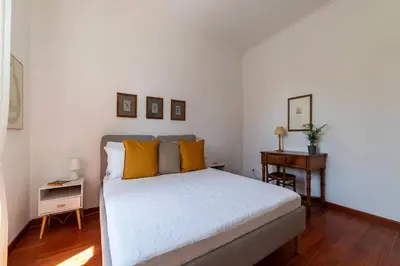 a bedroom with a bed with yellow pillows and a table at Casa Augusto - Charme Holidays in Rome