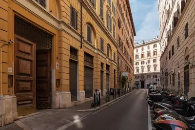 a row of motorcycles parked on a street next to buildings at Casa Augusto - Charme Holidays in Rome