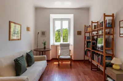 a living room with a couch and a book shelf at Casa Augusto - Charme Holidays in Rome