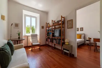 a living room with a tv and a book shelf at Casa Augusto - Charme Holidays in Rome