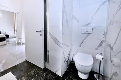 a white bathroom with a toilet and a shower at Vatican Suites in Cola Di Rienzo in Rome
