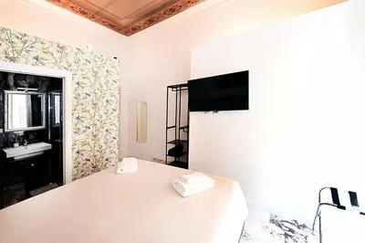 a white bedroom with a bed and a sink at Vatican Suites in Cola Di Rienzo in Rome