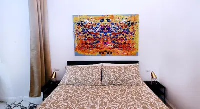 a bedroom with a bed and a painting on the wall at Vatican Suites in Cola Di Rienzo in Rome