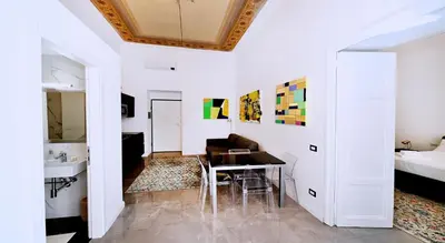 a white room with a table and a bed at Vatican Suites in Cola Di Rienzo in Rome