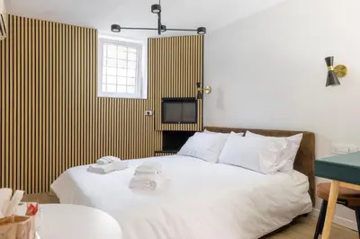 a bedroom with a white bed with a tv on the wall at MauveSweetRhome 4 in Rome