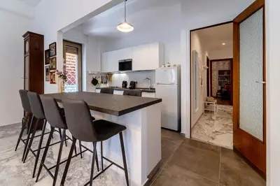 a kitchen with a table and chairs and a refrigerator at Casa Elena - 15 min walk to St Peter's Basilica in Rome