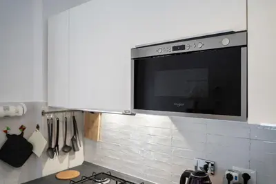a flat screen tv on a wall in a kitchen at Casa Elena - 15 min walk to St Peter's Basilica in Rome
