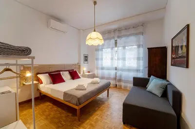 a bedroom with a bed and a couch at Casa Elena - 15 min walk to St Peter's Basilica in Rome