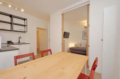 a kitchen and dining room with a wooden table and chairs at Porta Flaminia Suites in Rome