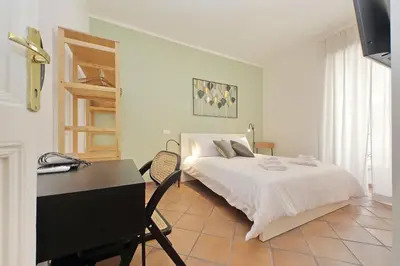 a bedroom with a white bed and a desk at Porta Flaminia Suites in Rome