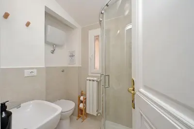a bathroom with a toilet and a sink and a shower at Porta Flaminia Suites in Rome